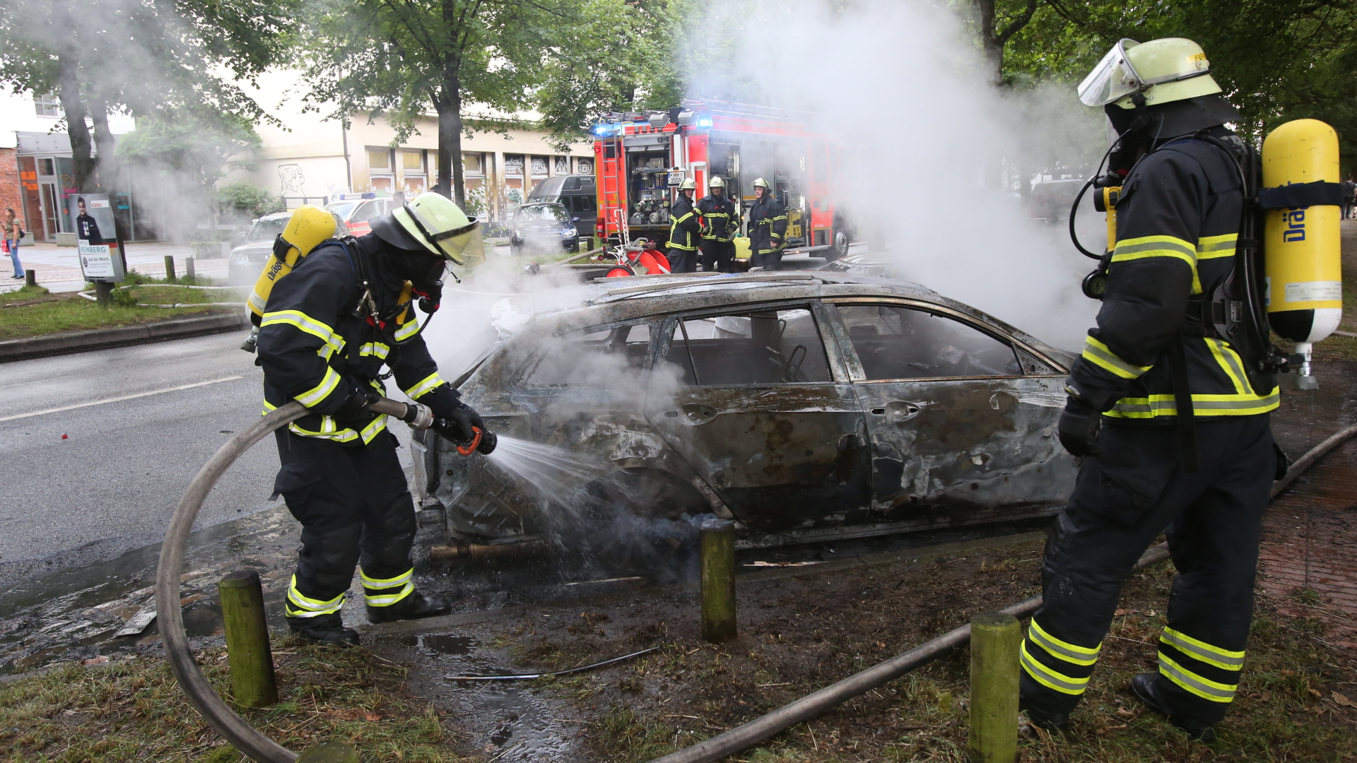  Feuerwehrleute löschen in Altona ein brennendes Auto.  | dpa