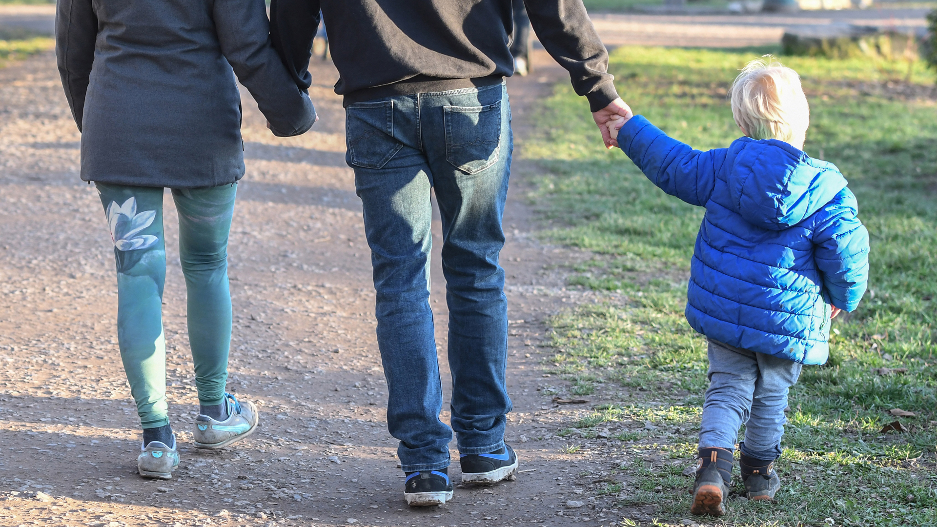 Rückenansicht von Eltern mit Kind beim Spaziergang | picture alliance / Winfried Roth