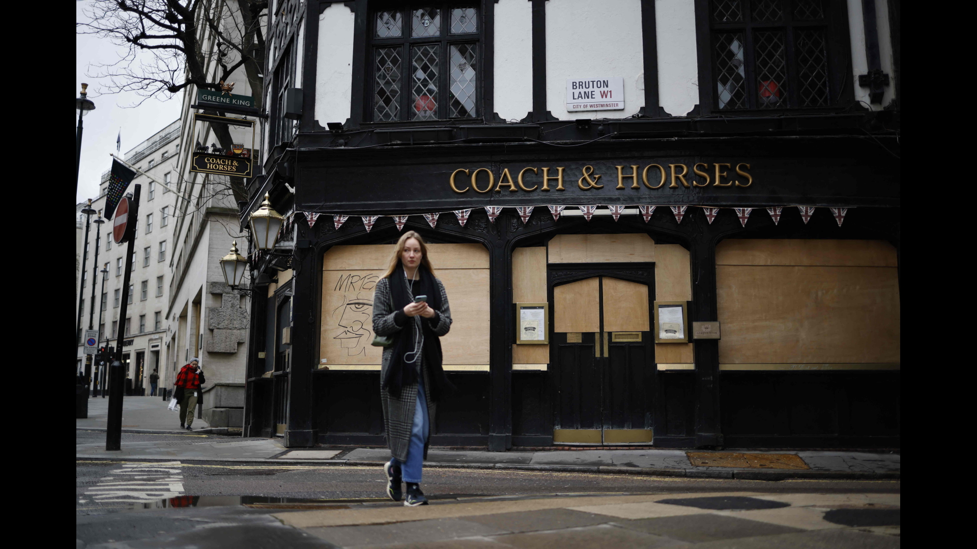 Eine Frau vor einem geschlossenen Pub in London | AFP