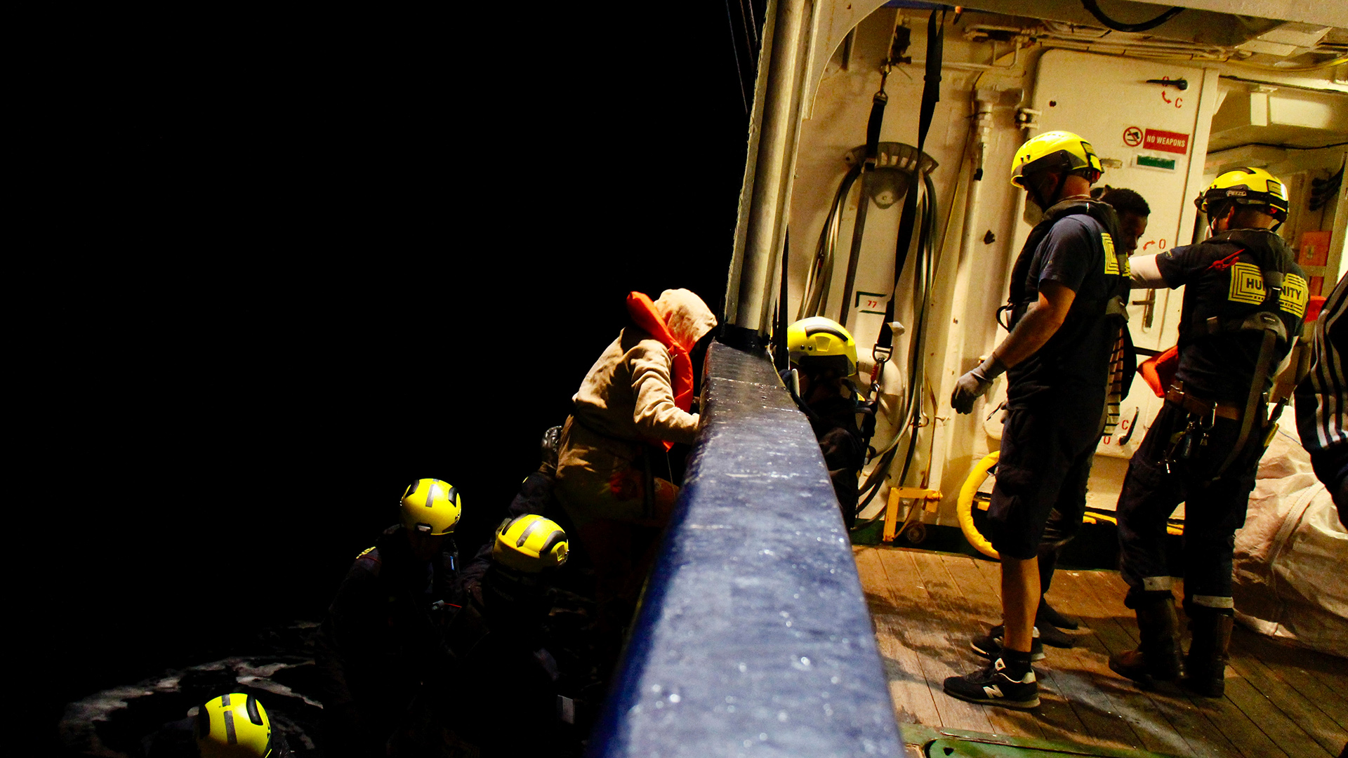 Migranten gehen an Bord eines Rettungsschiffes. | dpa