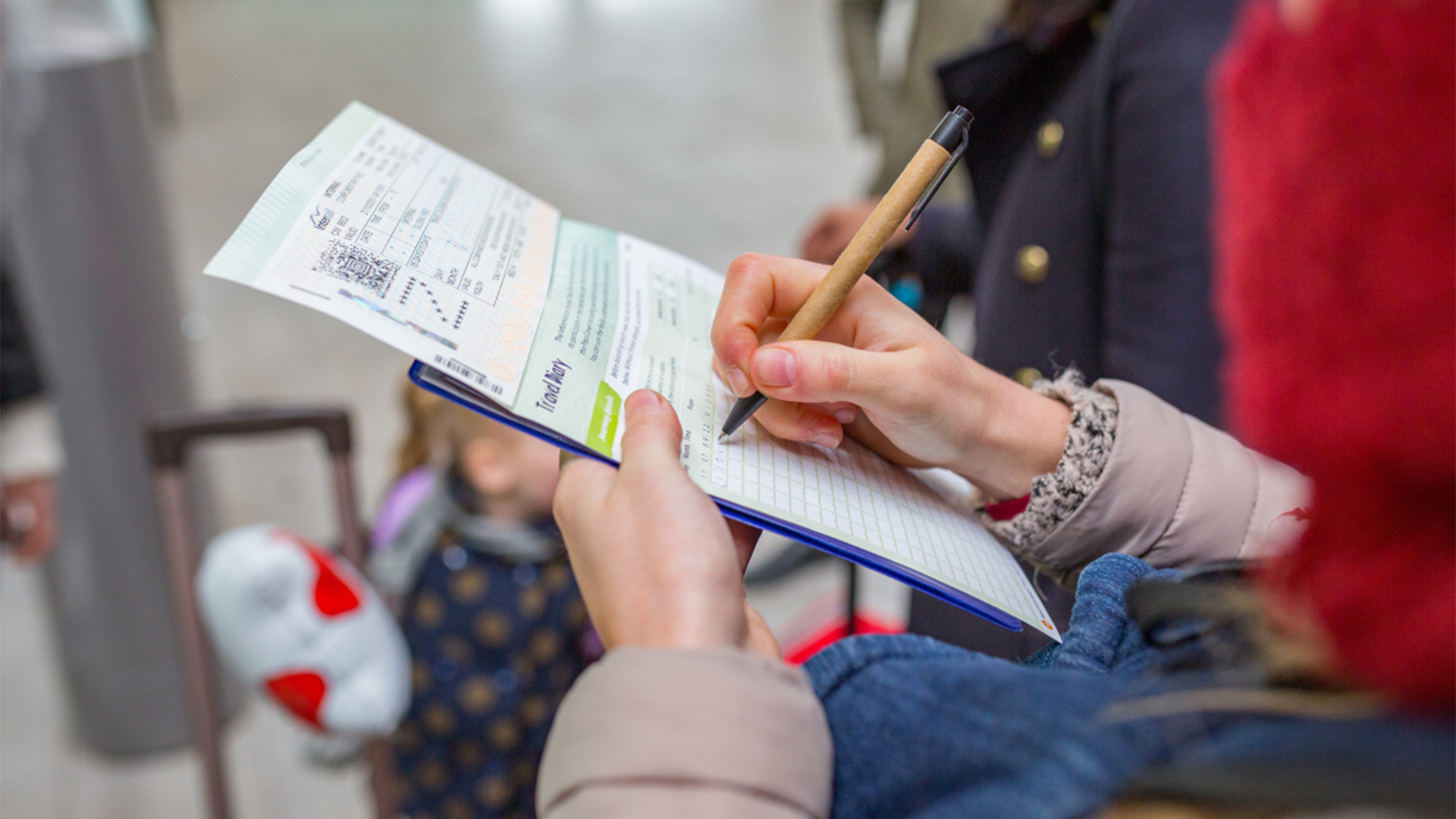 Eine Frau füllt das ''Reisetagebuch'' in einem Interrail-Ticket aus  | dpa