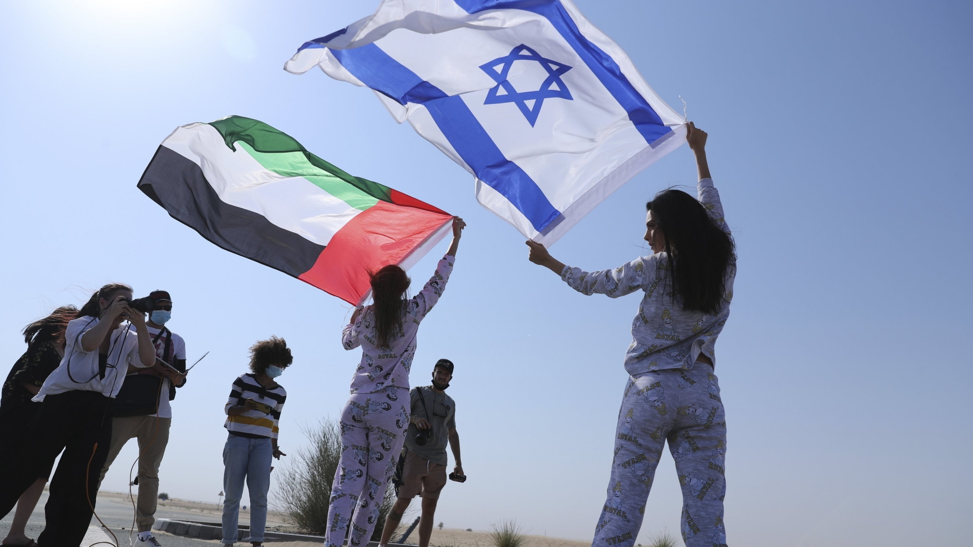 Zwei Models halten die Flaggen der Vereinigten Arabischen Emirate und Israels in die Luft | AP