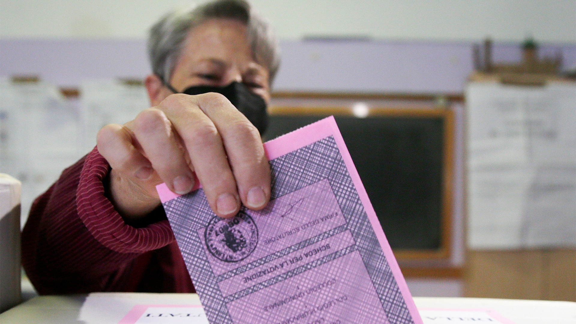 Eine Frau wirft ihren Stimmzettel zur Wahl in Italien in eine Wahlurne. | AP