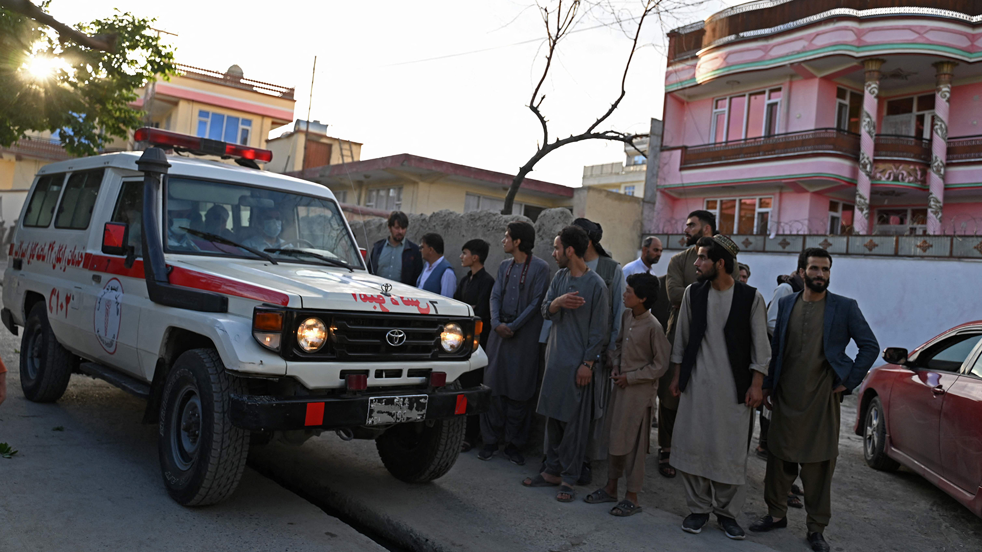 Schaulustige stehen neben einem Krankenwagen in Kabul (Afghanistan). | AFP