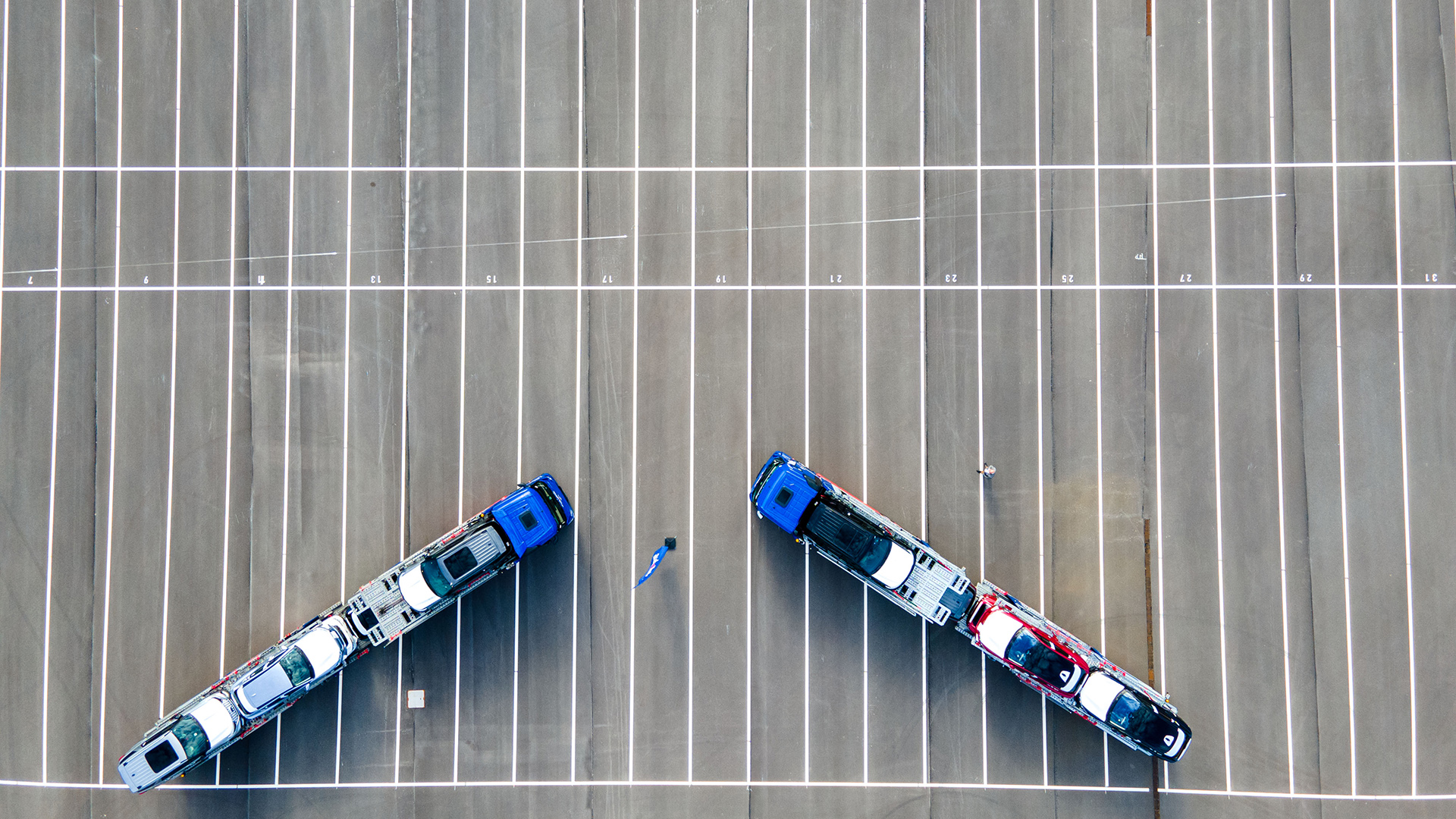 luftaufnahme: Zwei Autotransporter stehen auf einer leeren Stellfläche für Neuwagen | picture alliance/dpa