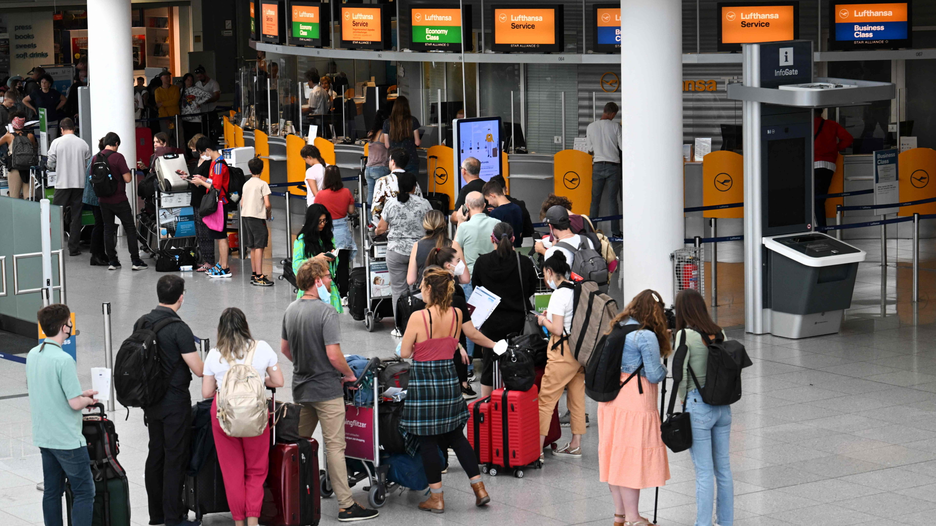 Passagiere stehen vor einem Lufthansa-Schalter am Flughafen München. | AFP
