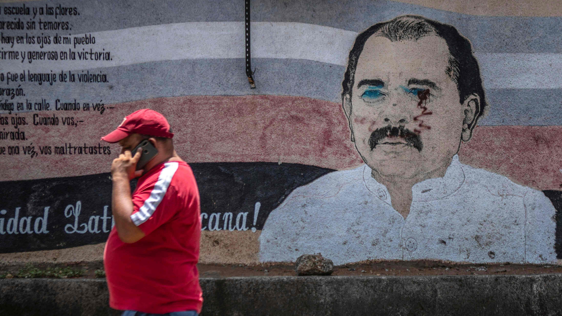 Ein Mann geht am einem Bild von Präsident Ortega vorbei. | AFP