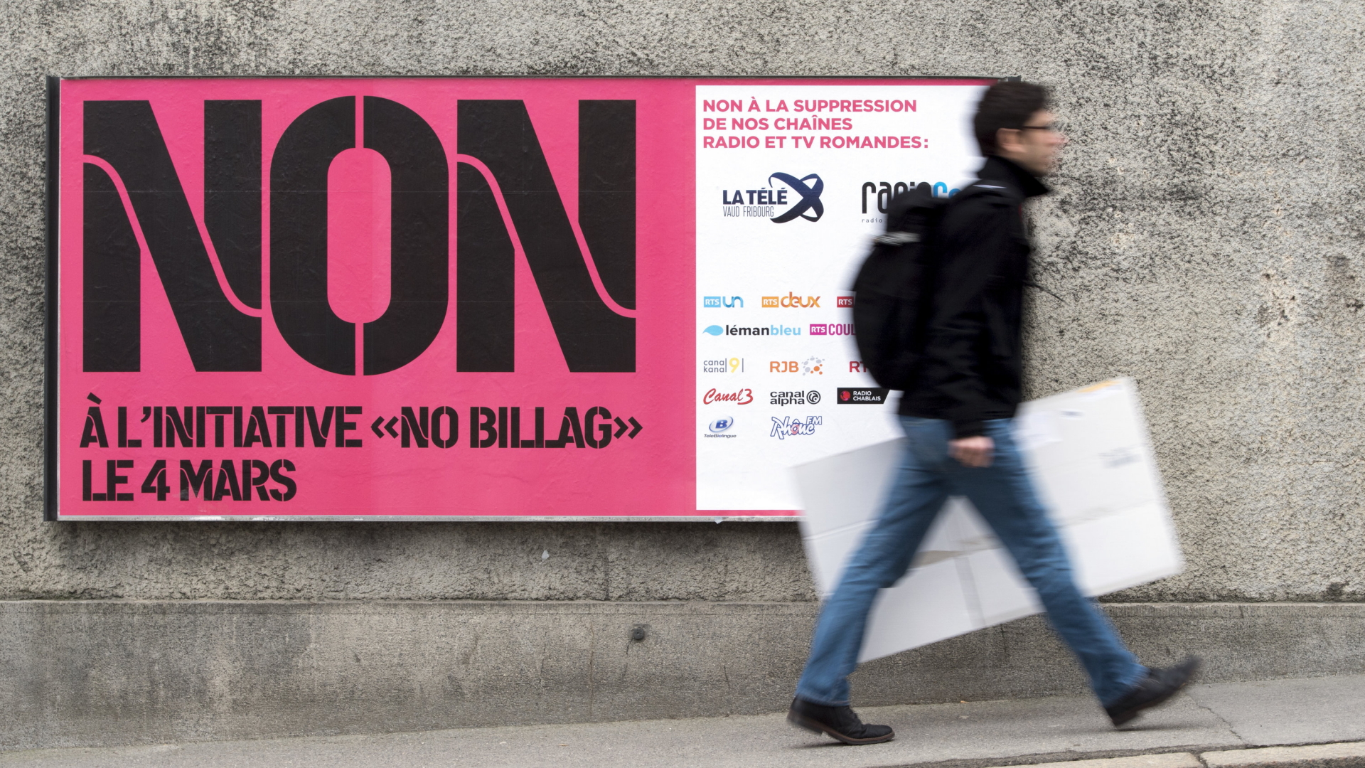 Ein Mann geht an einem Plakat der  "No Billag"-Initiative in der Schweiz vorbei. | AP