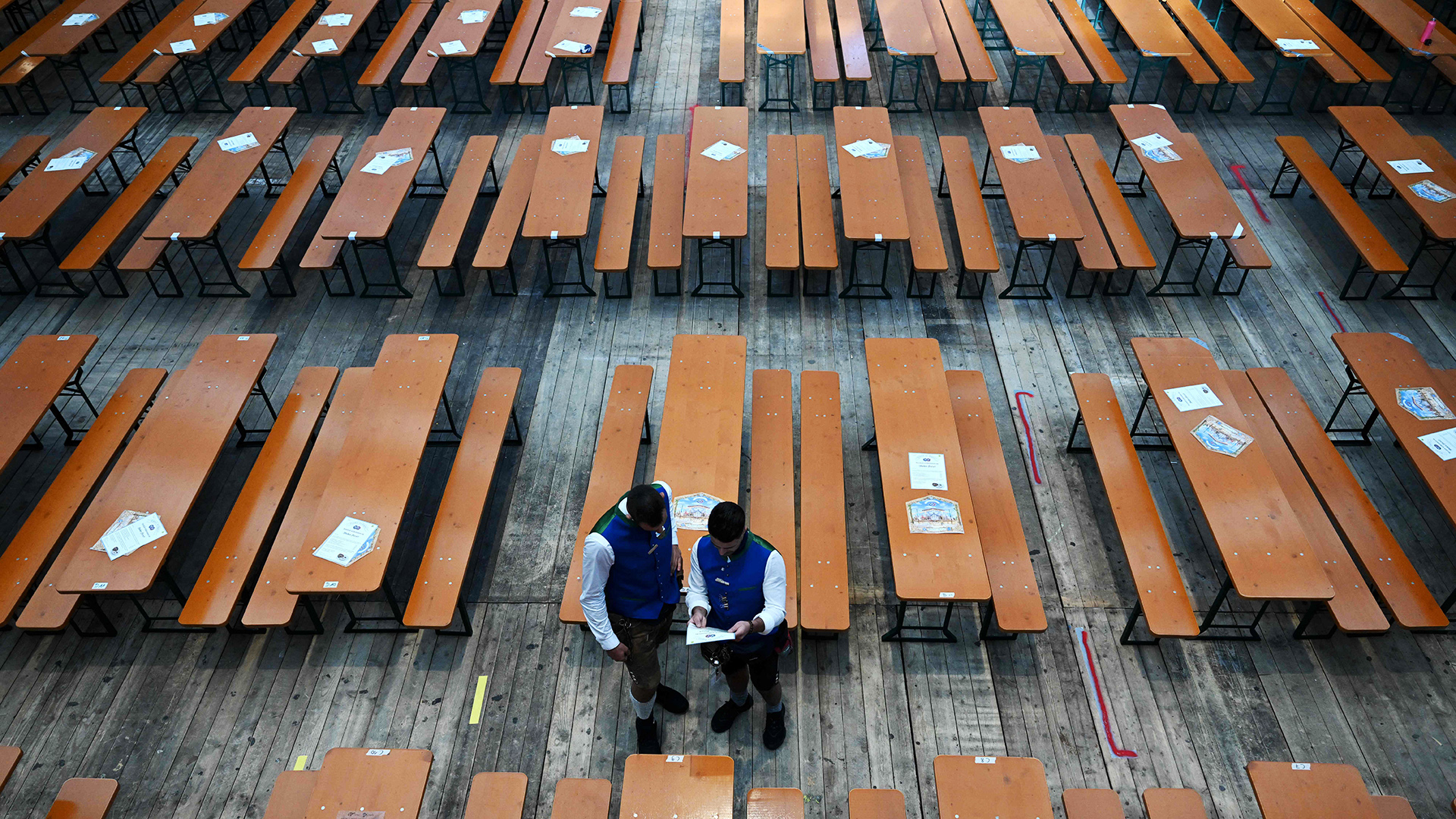 Zwei Männer stehen zwischen leeren Biertischen. | AFP