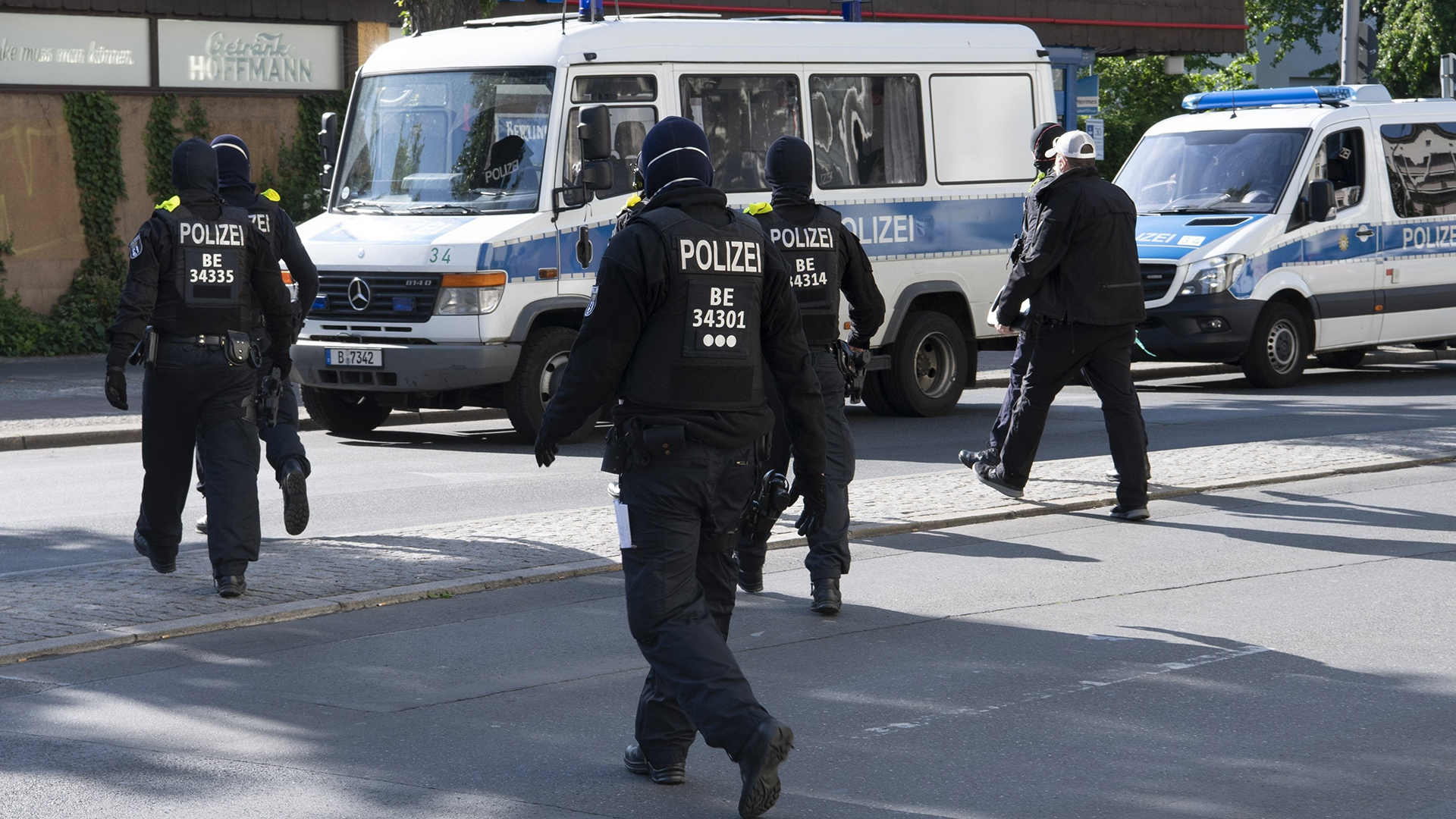 Polizisten laufen bei einer Razzia zu ihren Einsatzfahrzeugen, Archiv | picture alliance/dpa/dpa-Zentral