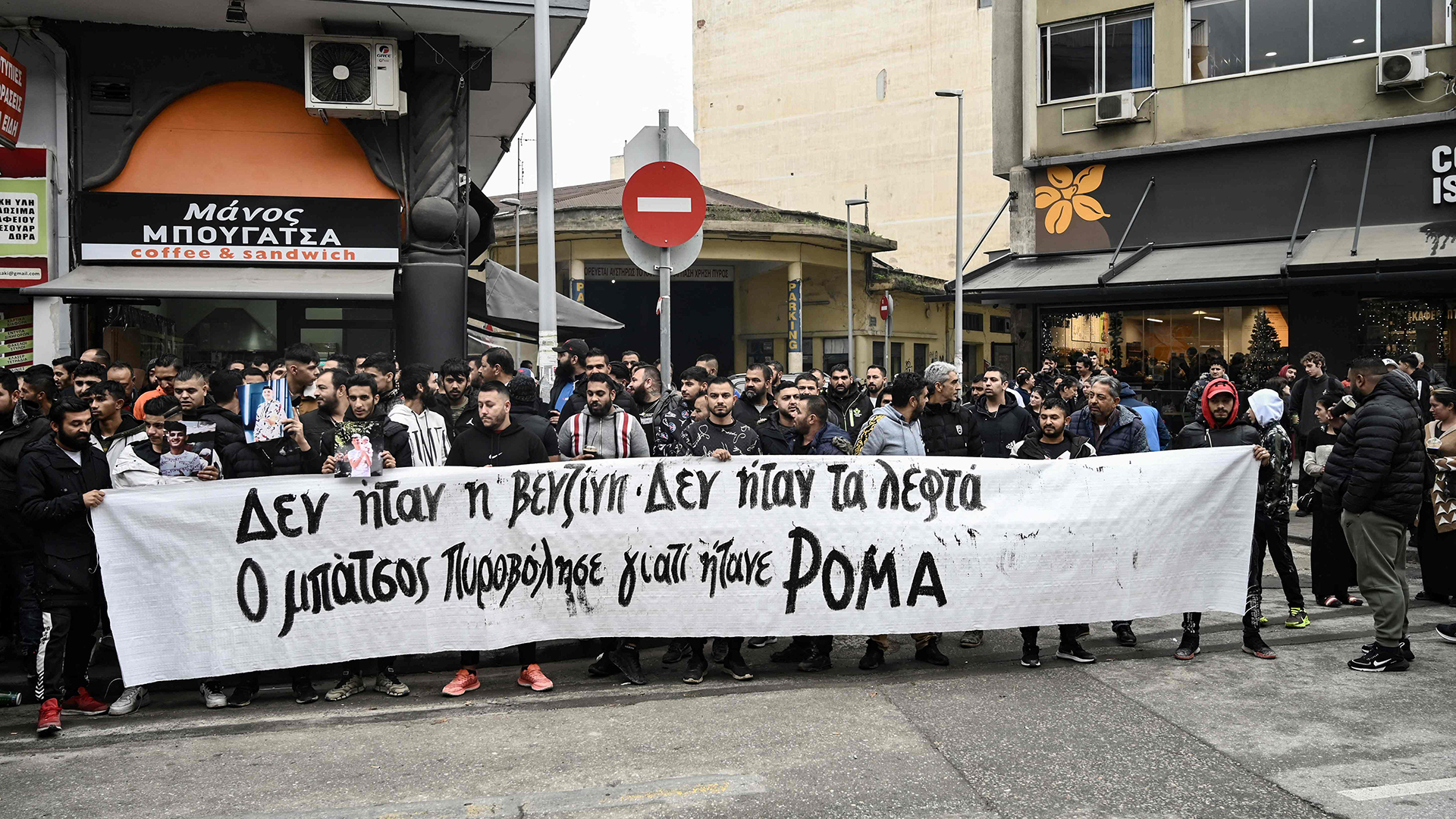 Mitglieder der Roma-Gemeinschaft in Griechenland halten während einer Demonstration vor dem Gerichtsgebäude in Thessaloniki ein Transparent mit der Aufschrift "Es war nicht das Benzin, es war nicht das Geld, der Polizist hat ihn erschossen, weil er ein Roma war". | AFP