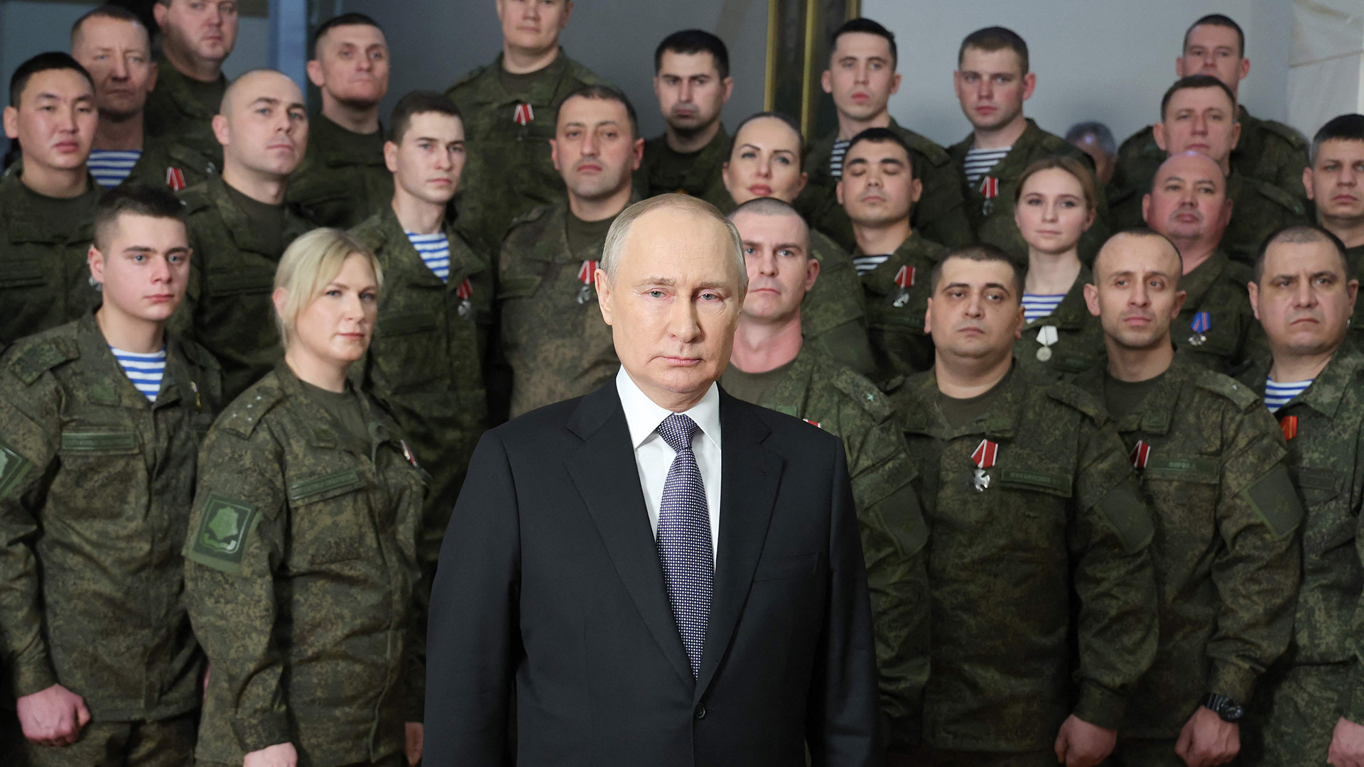Putin bei Neujahrsansprache - im Hintergrund Männer und Frauen in Militäruniform | AFP