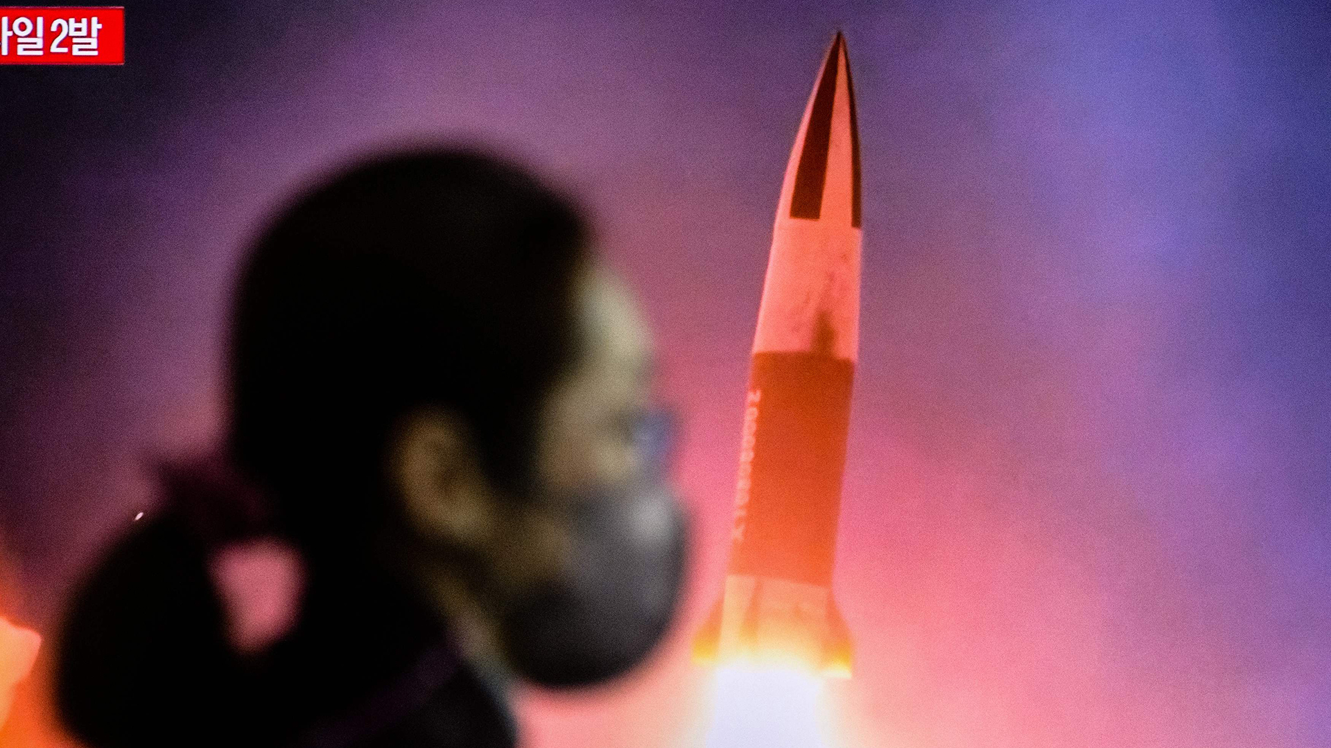 Eine Frau geht an einem Bahnhof in Seoul an einem Fernseher vorbei, auf dem eine Nachrichtensendung mit Aufnahmen von einem nordkoreanischen Raketentest gezeigt wird. | AFP