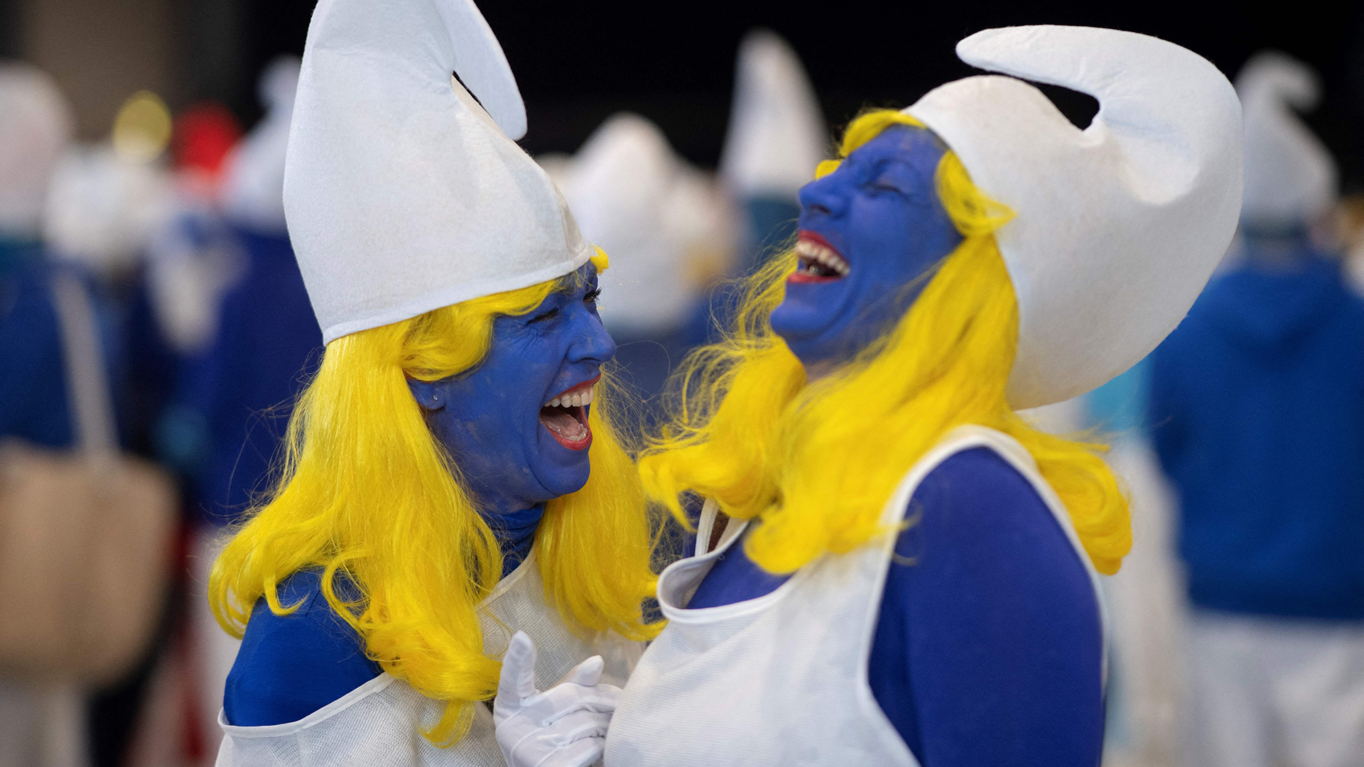 Zwei als Schlumpfine verkleidete Frauen lachen in Landerneau, Frankreich. | AFP
