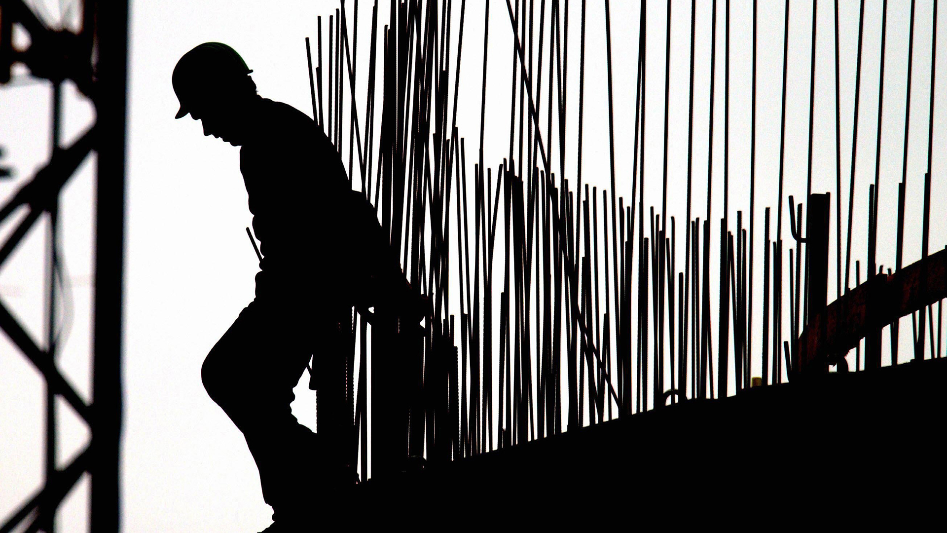 Silhouette eines Arbeiters auf einer Baustelle. | dpa