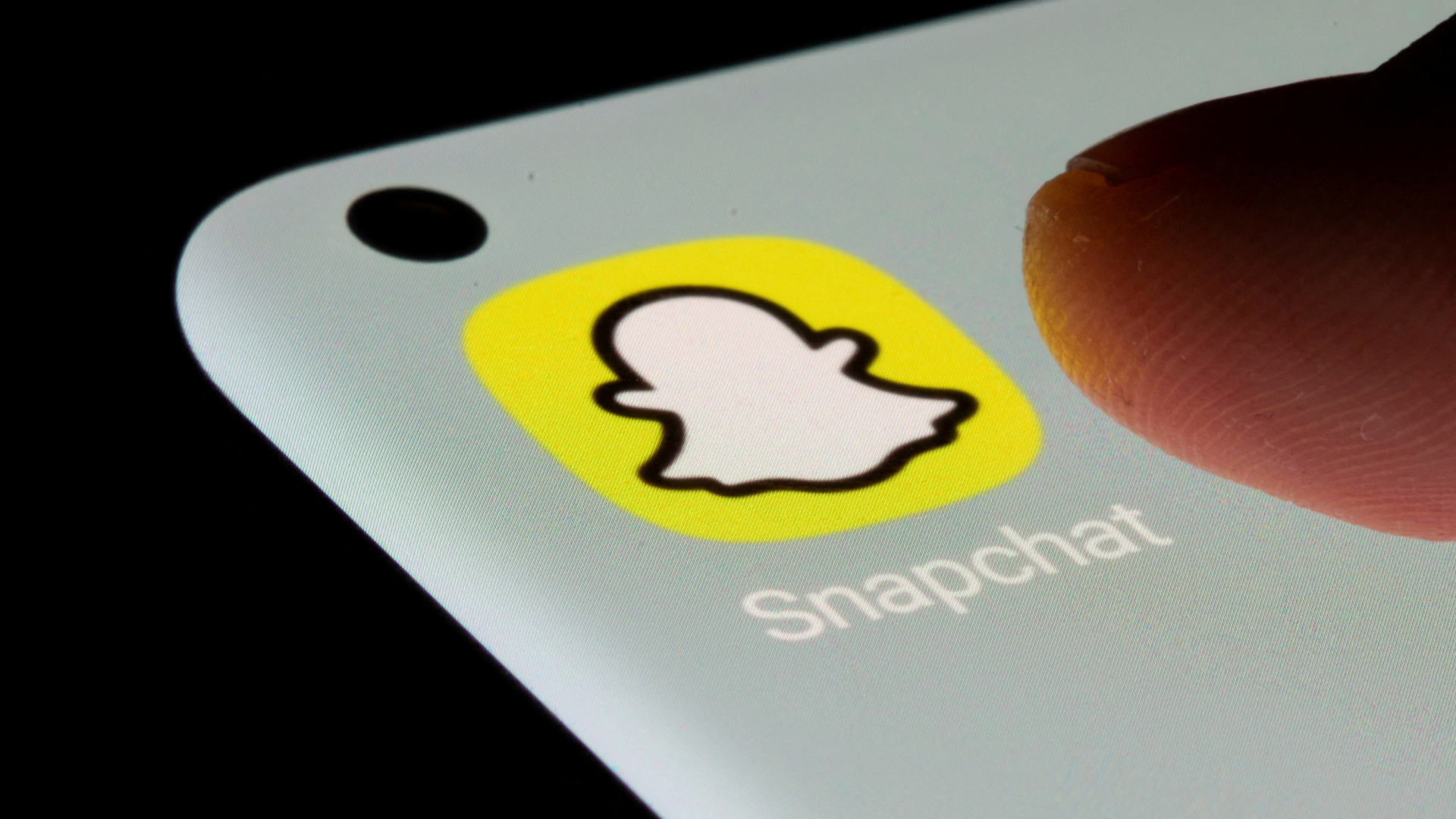 Finger drückt Symbol der App Snapchat auf einem Smartphone | REUTERS