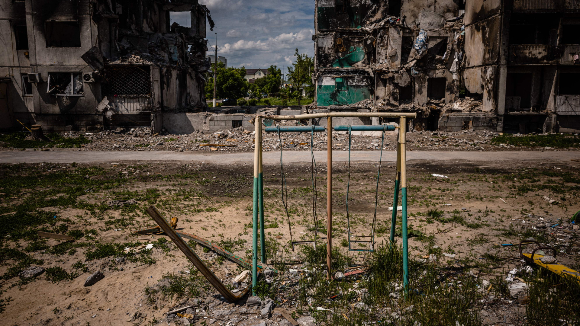 Eine Spielplatz-Schaukel vor zerstörten Wohngebäuden in der ukrainischen Stadt Borodjanka. | AFP