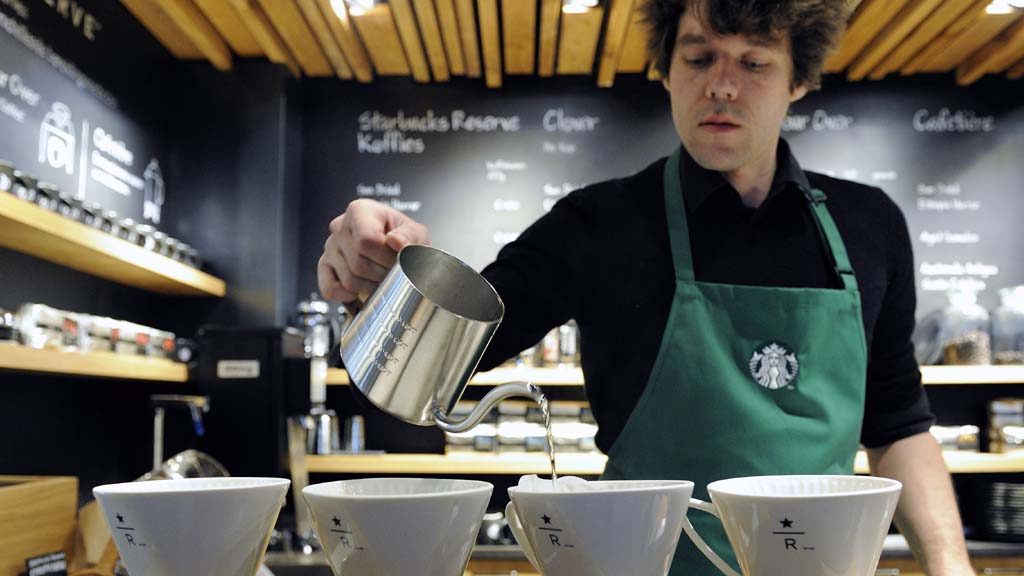Ein Starbucks-Mitarbeiter bereitet einen Kaffee zu. | picture alliance / dpa