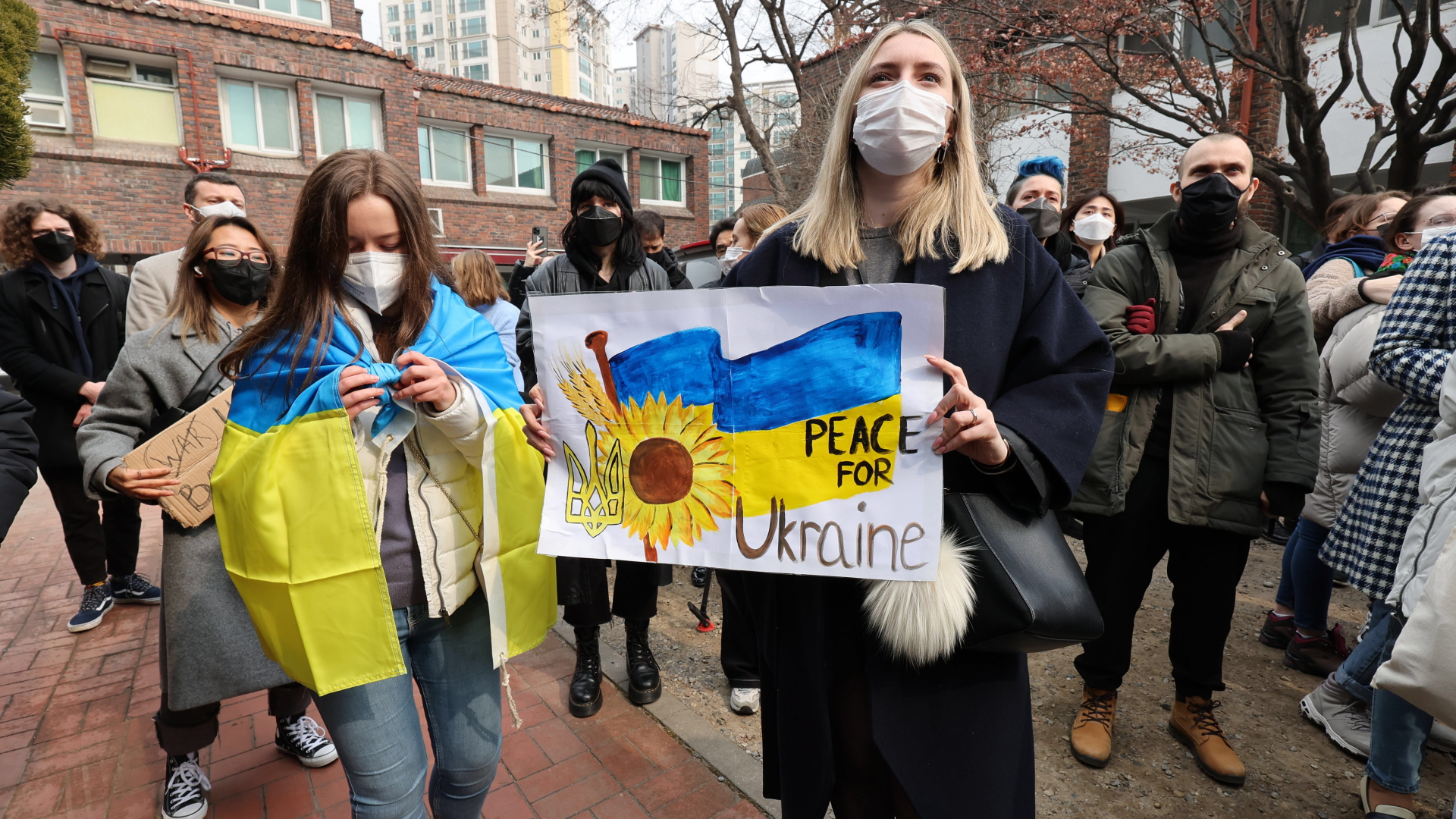 Ukrainerinnen und Ukrainer, die in Seoul leben, protestieren mit Plakaten gegen den russischen Angriff auf die Ukraine. | EPA
