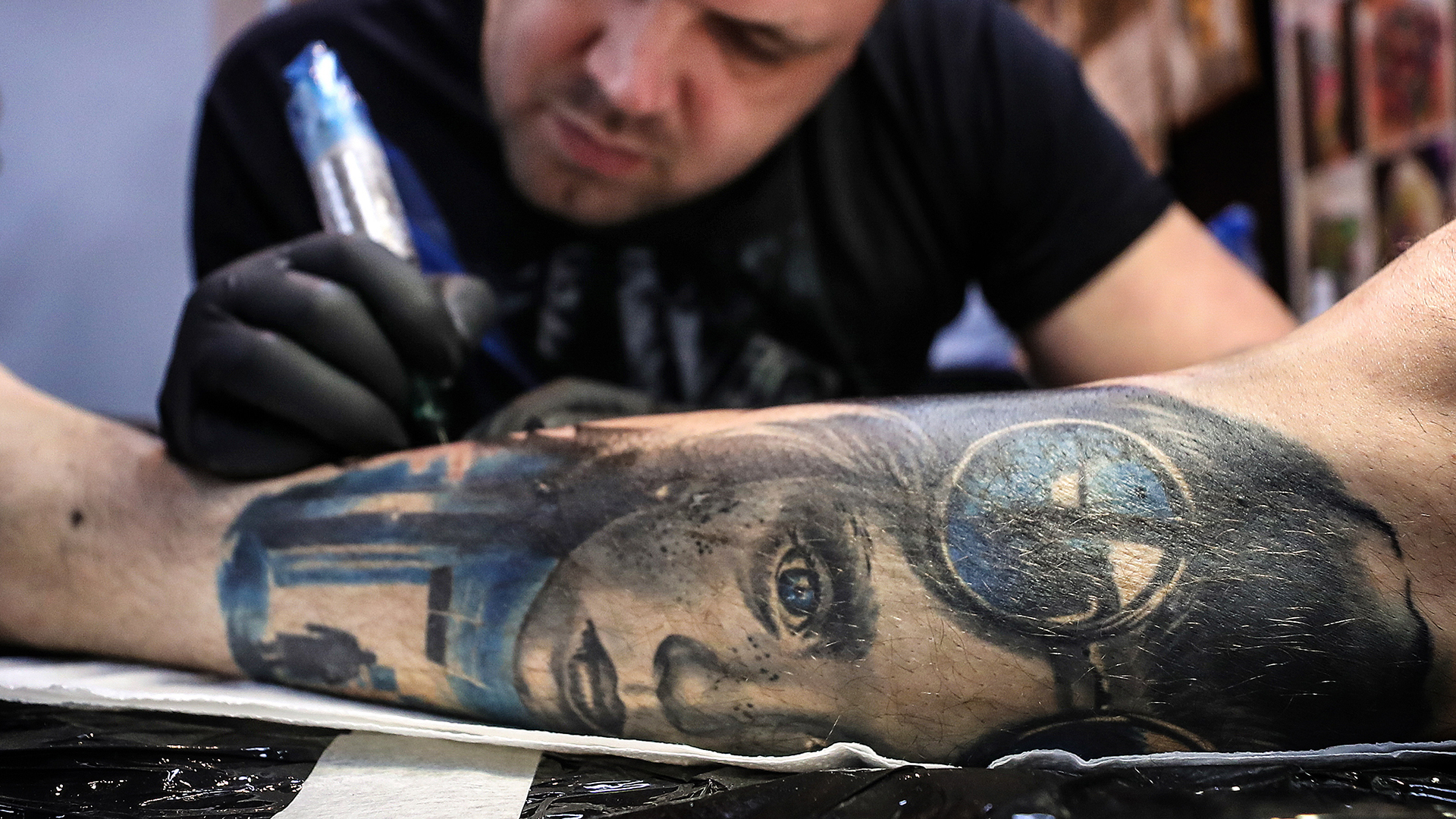 Ein Mann mit bunten Tattoos an den Unterarmen | picture alliance / Valery Sharif