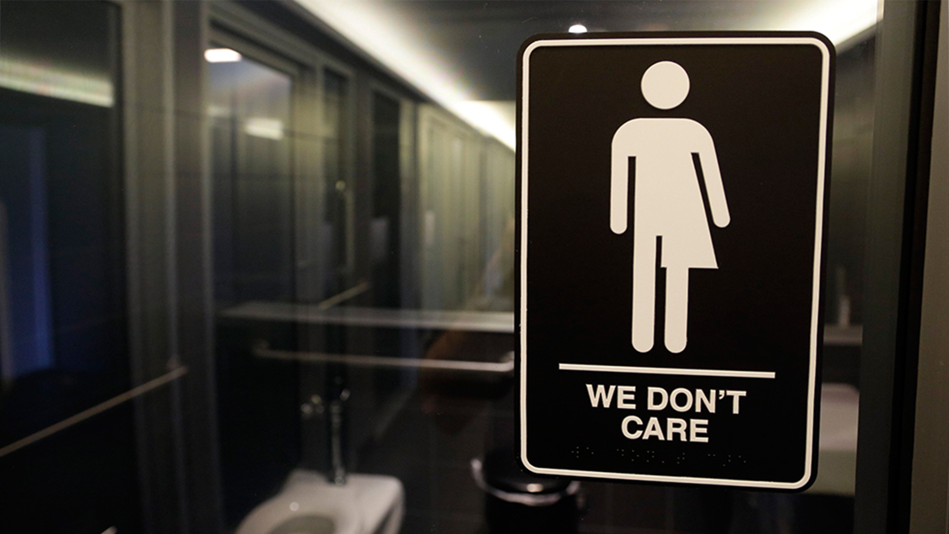 Geschlechtsneutrales Piktogramm am Eingang einer Hoteltoilette mit der Aufschrift: "We don't care" (deutsch: "Uns egal"). | AP