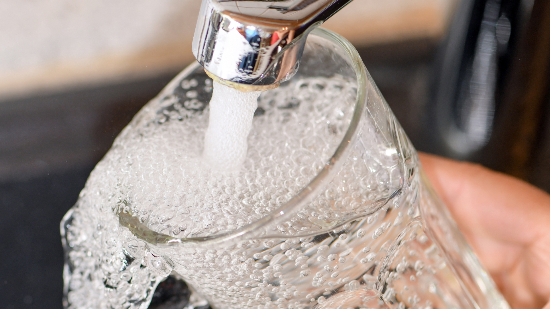 Am Wasserhahn in einer Küche wird ein Trinkglas mit Leitungswasser befüllt. | dpa
