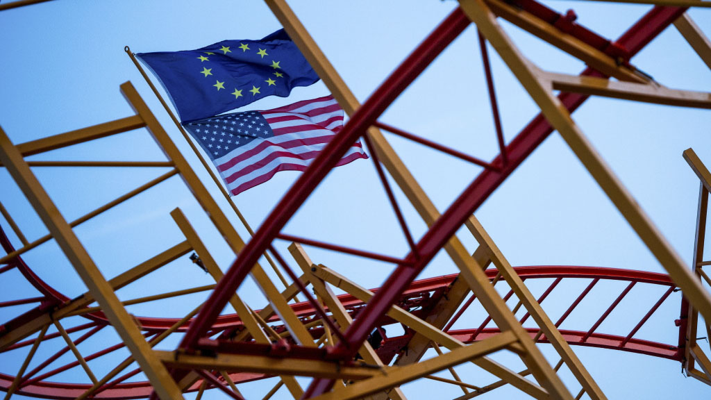 Flaggen der USA und der EU wehen über einer Achterbahn | null