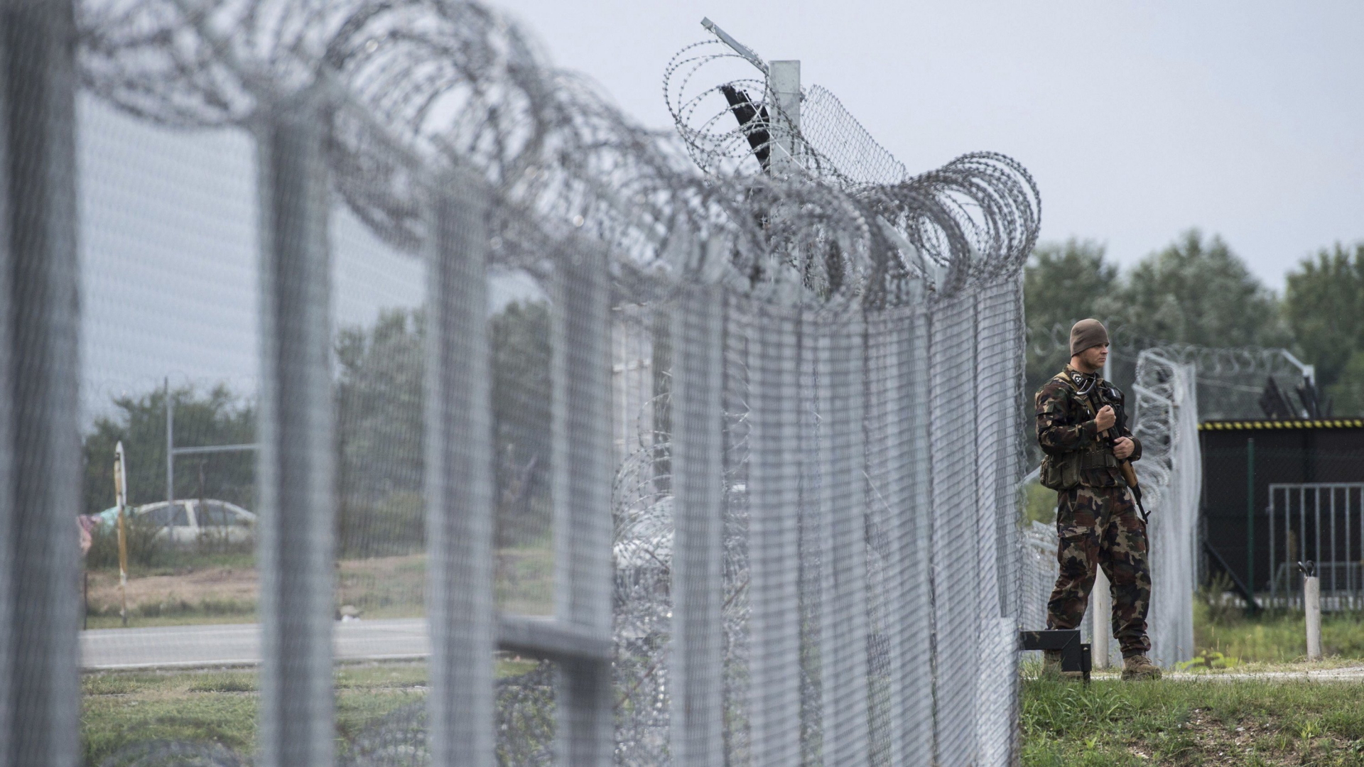 Ein ungarischer Soldat patrouilliert vor einer sogenannten Transitzone an der Grenze zu Serbien (Archivbild). | dpa