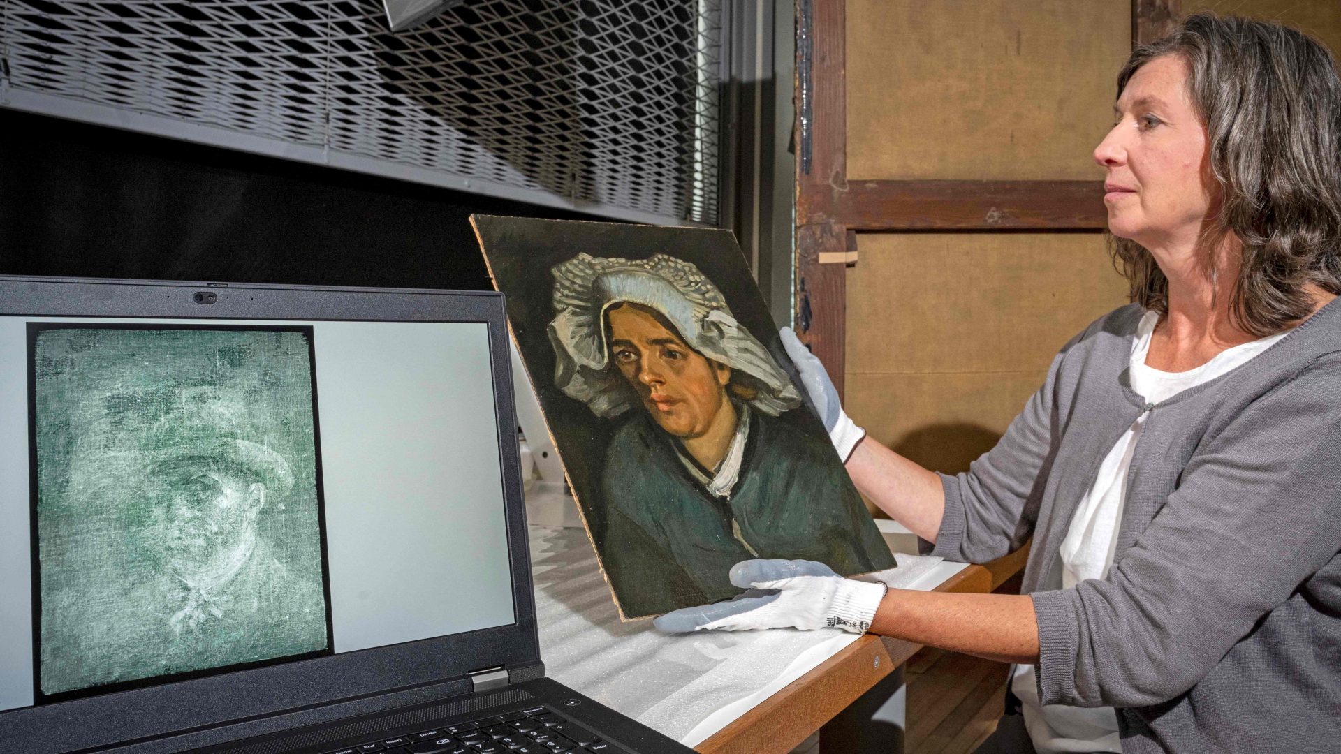 Lesley Stevenson betrachtet das Gemälde "Kopf einer Bäuerin" neben dem Röntgenbild eines versteckten Selbstporträts des niederländischen Malers Vincent Van Gogh | AFP