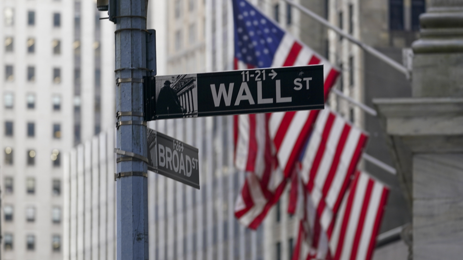 Fahnen hängen vor der Börse an der New Yorker Wall Street. | AP