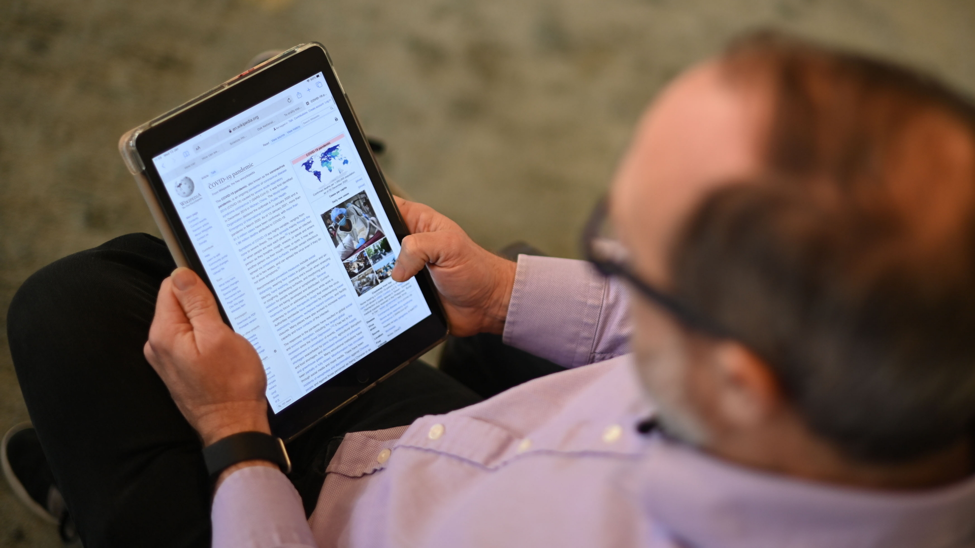 Ein Mann hat auf einem Tablet die Wikipedia aufgerufen. | AFP