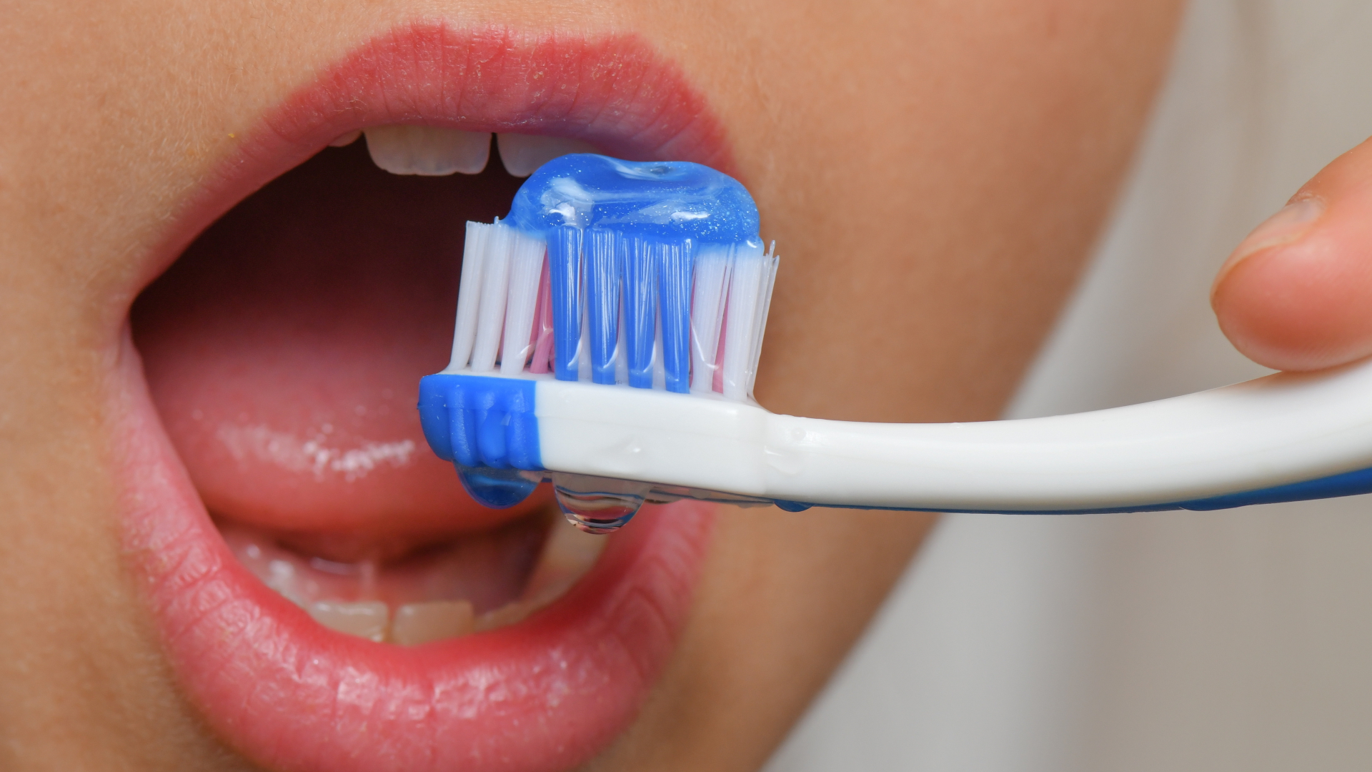 Zahnbürste vor einem geöffneten Mund | dpa